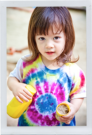 Photograph: A female toddler pours sand from one container to another. (Photograph by Alex Lazara)