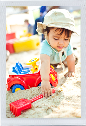 Photograph: An toddler reaches for his shovel in a sandbox. (Photograph by Alex Lazara)